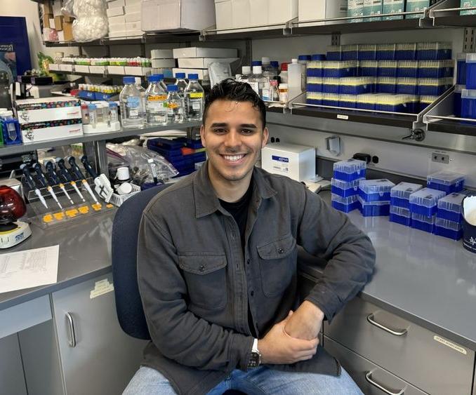 Erick Astacio surrounded by laboratory equipment